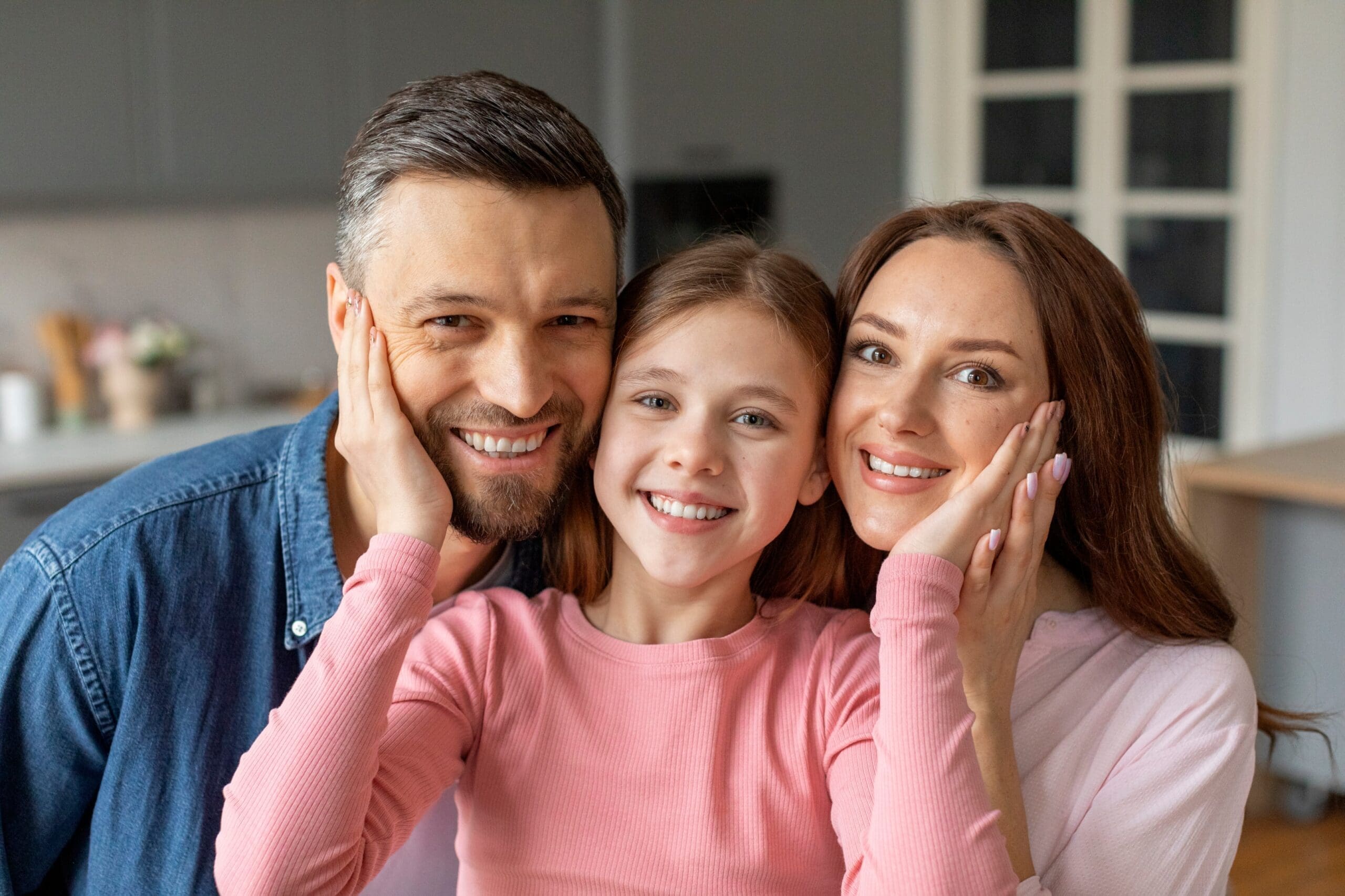 parents smiling with child after getting her a retainer Parents and child celebrating successful orthodontic treatment with a fixed retainer